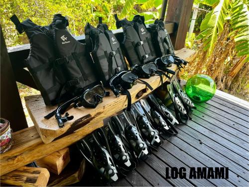 a row of baseballpacks andhelmets on a wooden table at LOG AMAMl 1棟貸切ログハウス in Setouchi