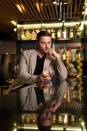 a man in a suit holding a wine glass at Park Plaza Bangkok Soi 18 in Bangkok
