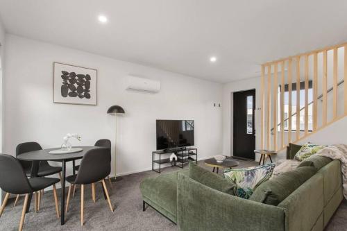 a living room with a green couch and a table at Great Deals at New Upmarket Appt in Linwood