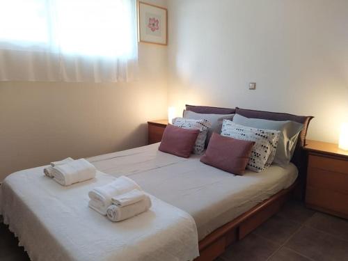 a bedroom with a bed with towels on it at Garden house by the sea in Vari
