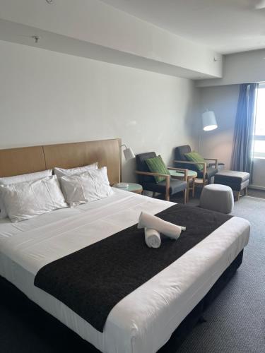 a bedroom with a large bed with a black blanket at Pandanas Studio Darwin CBD Water Views in Darwin