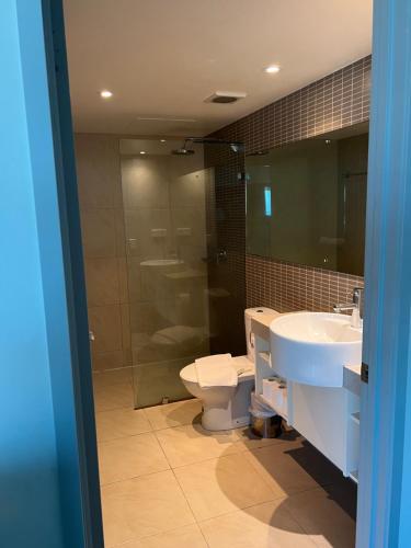 a bathroom with a sink and a toilet and a mirror at Pandanas 15th floor (Water, City & Sunset views) in Darwin
