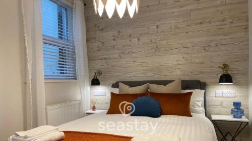 a bedroom with a bed with a wooden accent wall at The Panoramic - Beach Front Apt - No Guest Fees in Kent