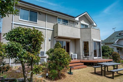 a house with a picnic table in front of it at ガーデンテラス伊豆高原 in Futo