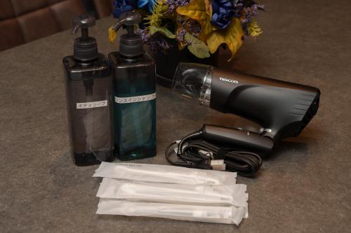 a hair dryer next to two bottles of alcohol at 三和泉 in Beppu