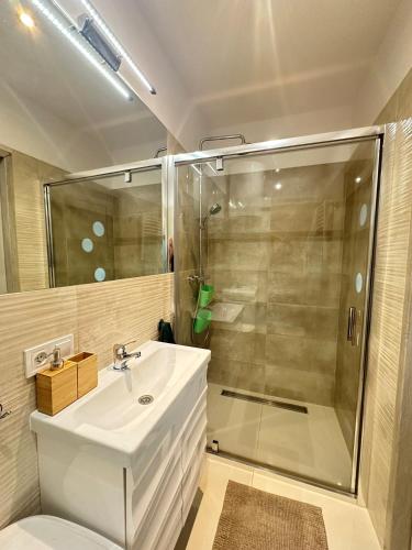 a bathroom with a white sink and a shower at Dom wakacyjny z sauną i ogrodem na wyłączność in Drawno