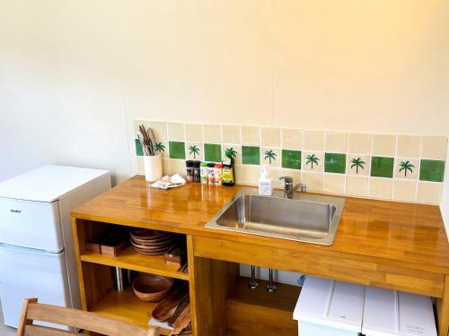a kitchen counter with a sink and a refrigerator at TAITO BEACH HOUSE in Ichigaya
