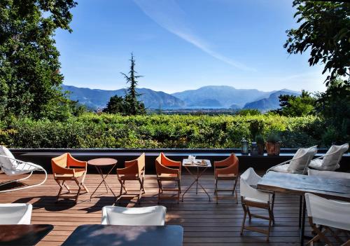 a patio with tables and chairs and mountains in the background at L'Albereta Relais & Chateaux in Erbusco