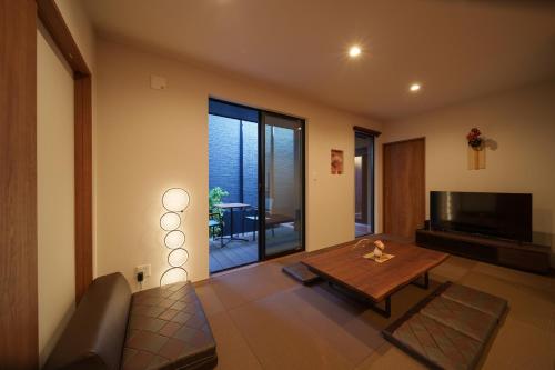 a living room with a table and a television at 三和泉 in Beppu