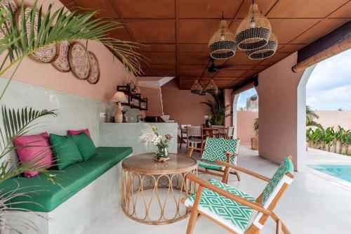a patio with a couch and chairs and a table at Woywoy Escape Tabo - Adults Only in Ubud