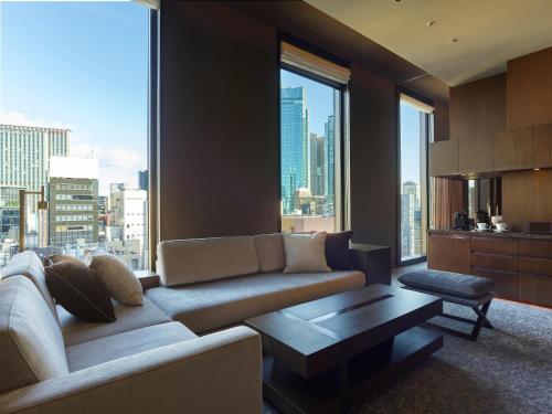 a living room with a couch and a large window at Hotel The Celestine Ginza in Tokyo