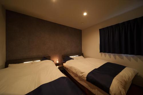 a bedroom with two beds and a window at 三和泉 in Beppu