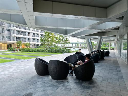 a woman sitting on a row of chairs in a building at GemstoneBR in SMDC Fame Residences in Manila