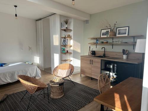 un salon avec un lit, une table et des chaises dans l'établissement Charmant studio au pied des Arenes de Arles, à Arles