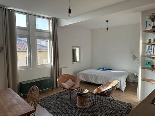 une chambre avec un lit, des chaises et une table dans l'établissement Charmant studio au pied des Arenes de Arles, à Arles