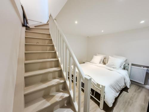 - une chambre avec un lit à côté d'un escalier dans l'établissement PenBed - Montparnasse 1 - 3 pièces, à Paris
