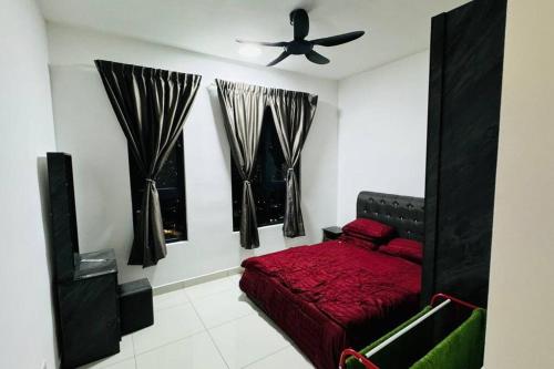 a bedroom with a red bed and a ceiling fan at Homestay Sri Anggun Trio Setia Klang in Batu Unjor