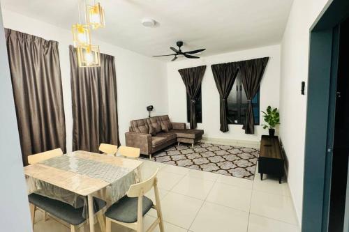 a living room with a table and a couch at Homestay Sri Anggun Trio Setia Klang in Batu Unjor