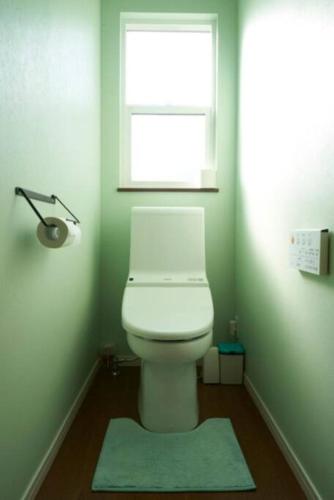 a bathroom with a toilet with a window and a rug at SAUNA Villaサンタフェリゾート富津 in Minato
