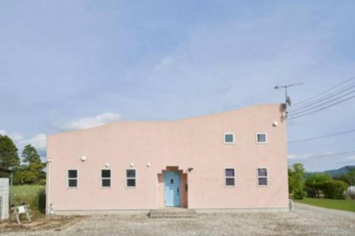 a large brick building with a blue door at SAUNA Villaサンタフェリゾート富津 in Minato