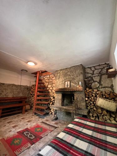 a room with a fireplace and a pile of logs at Chata svätého Filipa in Hnilčík