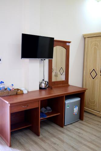 a wooden desk with a television on top of it at Kim Ngân Hotel Buôn Ma Thuột in Buon Ma Thuot