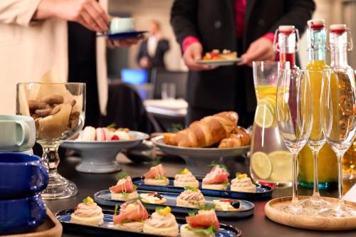 a table topped with plates of food and glasses of wine at Sheraton Zagreb Hotel in Zagreb