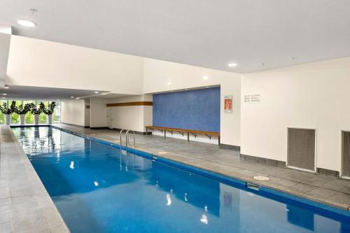 a large swimming pool in a building with a projection screen at Modern Renovated CBD Apartment in Canberra