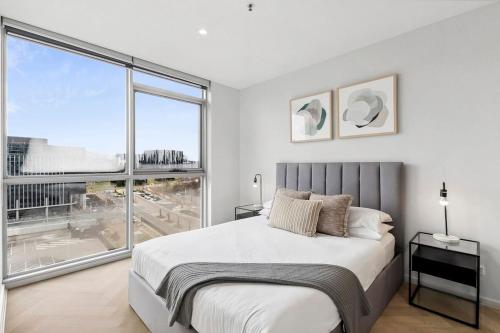a bedroom with a large bed and a large window at Modern Renovated CBD Apartment in Canberra
