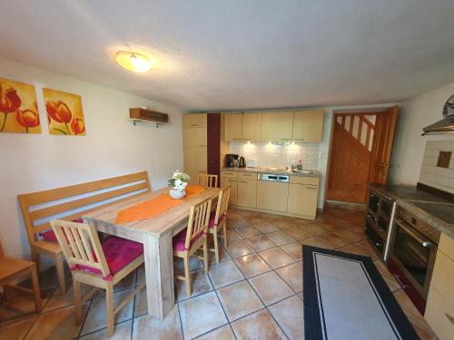 a kitchen with a wooden table and chairs in a room at Ferienhaus Gerold Grießer in Umhausen