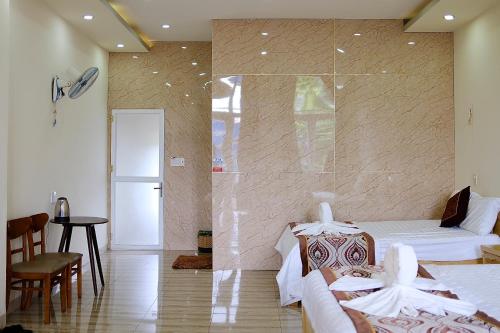a bedroom with two beds and a glass wall at Kim Ngân Hotel Buôn Ma Thuột in Buon Ma Thuot