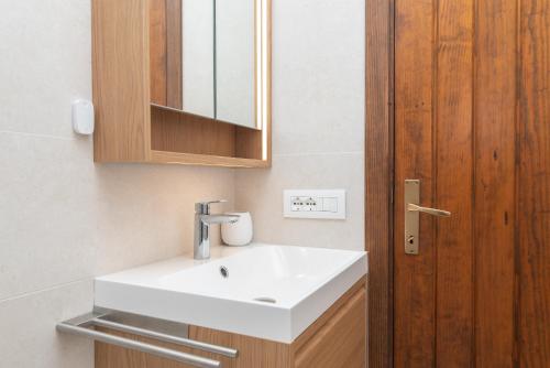 baño con lavabo blanco y puerta de madera en Relax Porto Mannu, en Palau