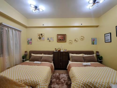two beds sitting next to each other in a bedroom at SyHOME-Suites in Trece Martires