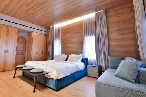 a bedroom with a large bed and a couch at KCOR Hotels in Ḩārat at Taḩtā