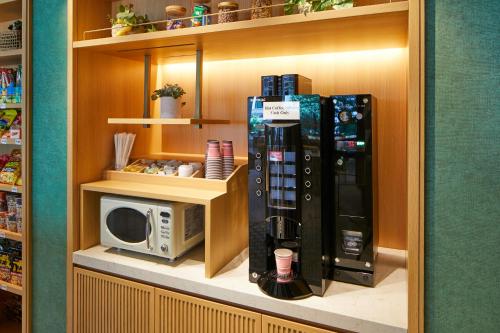 a kitchen with a microwave and a refrigerator at The Royal Park Hotel Ginza 6-Chome in Tokyo