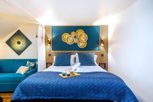 a bedroom with a blue bed and a blue couch at La Tanière du Roi - Versailles - à 10 min du Château et de la gare in Versailles