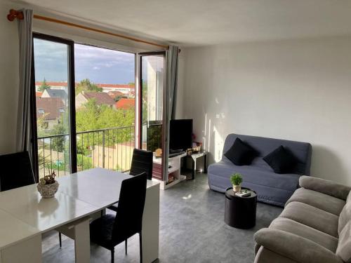 un salon avec un canapé bleu et une table dans l'établissement Studio superbe vue 1 canapé-lit, à Choisy-le-Roi