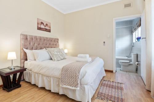 a bedroom with a large white bed and a toilet at Gainsford Place 26 by Host Agents in Durban