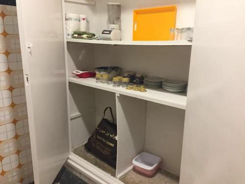 a shelf with dishes and a bag in a kitchen at Appartement Hamria Central in Meknès
