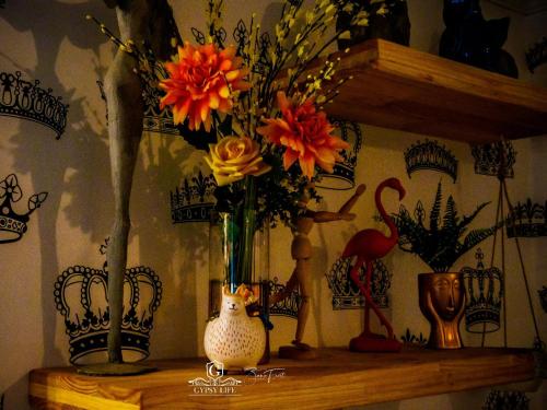 a wooden shelf with a vase of flowers on it at Gypsy Guest House Clarens in Clarens