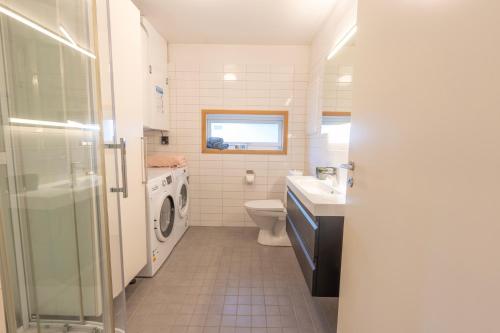 a bathroom with a toilet sink and a washing machine at Tromsø Town and Nature in Trondalen