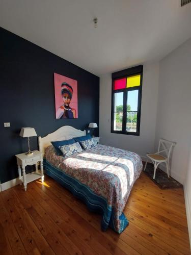 une chambre avec un grand lit avec un tableau au mur dans l'établissement Arcachonnaise - centre ville - 500m de la plage, à Arcachon