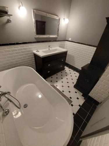 une salle de bain avec une baignoire blanche et un lavabo dans l'établissement Arcachonnaise - centre ville - 500m de la plage, à Arcachon