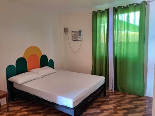 a bedroom with a bed with green curtains at Estefania Homestay in Santa Monica