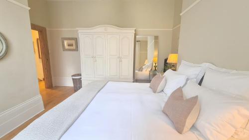 a large white bed with white pillows in a room at Crouch End Apartment - Spacious flat close to Central London in London