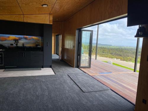 a room with a large glass door with a view at Fenian Retreat in Karamea
