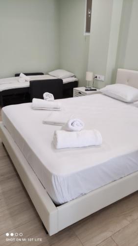 a large white bed in a room with towels on it at Diacopto Country Houses in Diakopto