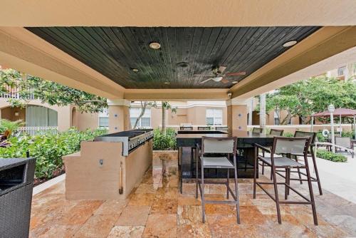 a patio with a table and chairs and a grill at The Costal, stunning water view apartment at Aventura Yacht Club, Miami Florida! in Sun Swept Isles