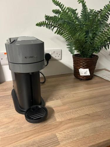 a coffee maker sitting on the floor next to a plant at Appletree Cottage in Ballyduff