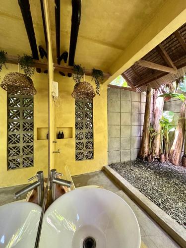 a bathroom with a white sink in a room at Alpas Siargao in General Luna